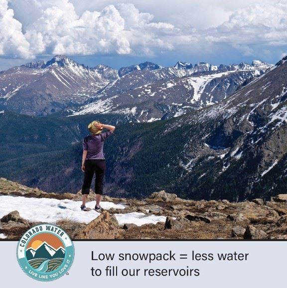 image of woman standing on top of mountain and looking at the snowy mountain vista