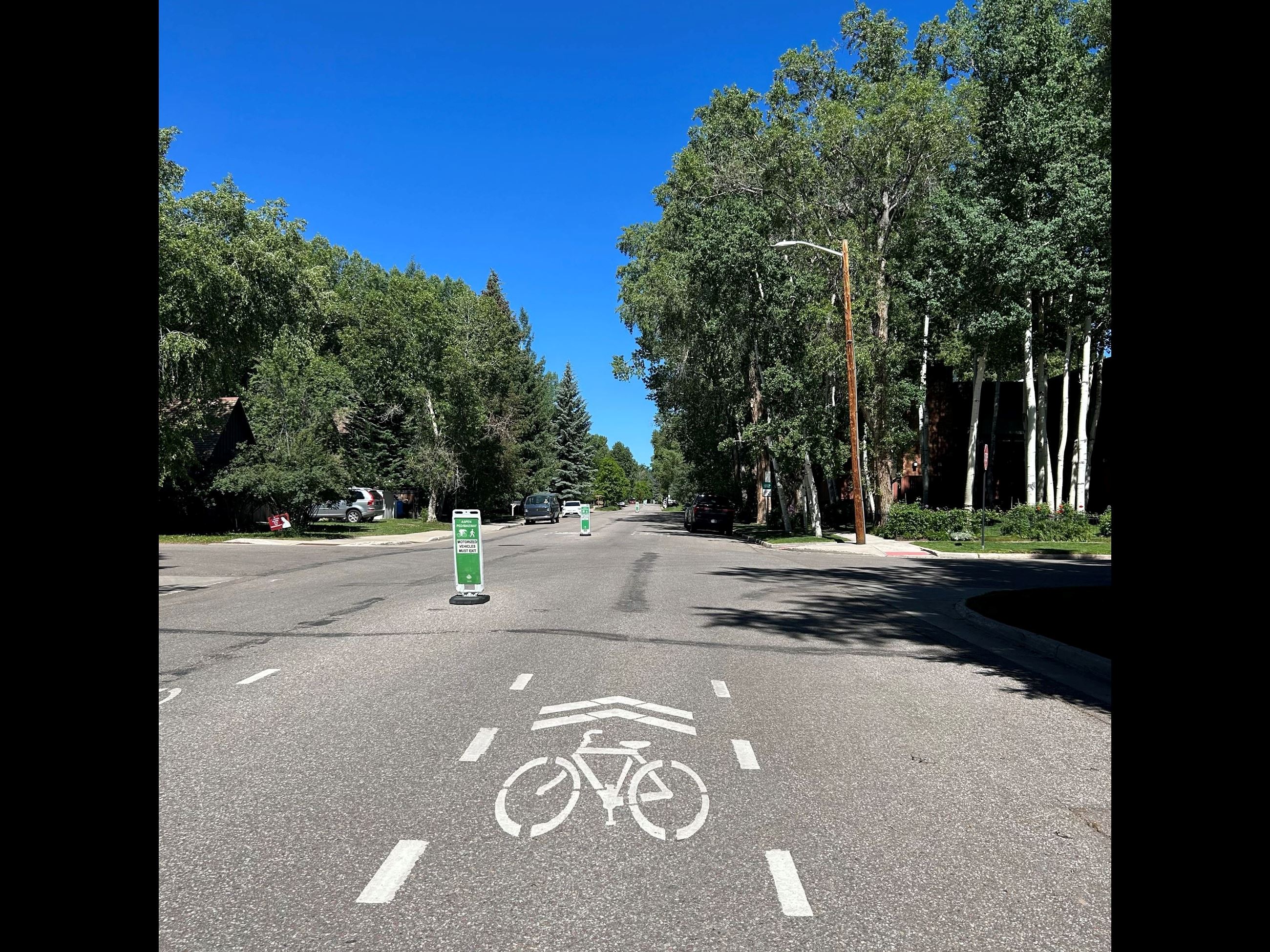 white bike path sign on asphalt road