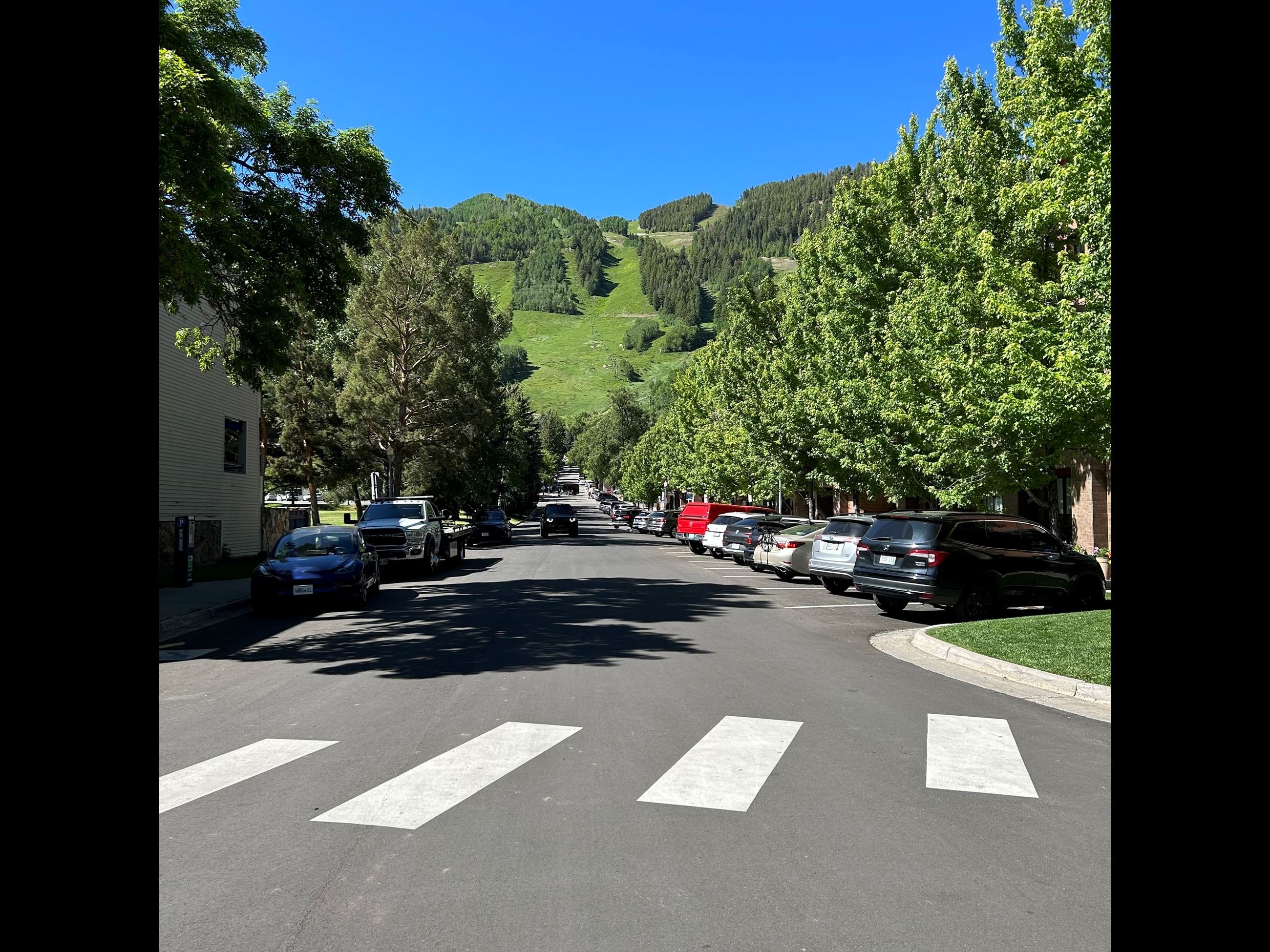 white crosswalk with the green aspen mountain in the background 