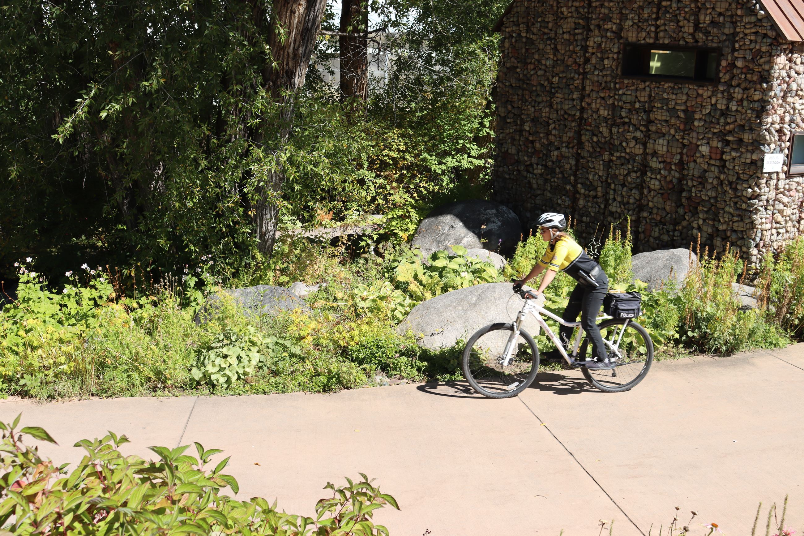 Female police officer in yellow uniform riding a bike